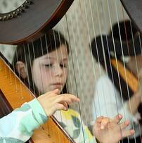 Photo d'un enfant jouant de la harpe