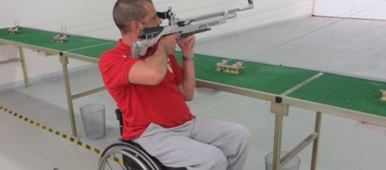 Photo d'une personne en fauteuil roulant qui tire à la carabine