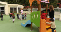 Photo d'enfants se dirigeant vers un toboggan dans une aire de jeux dans une crèche verte