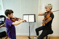 Photo d'un professeure et enfant jouant du violon